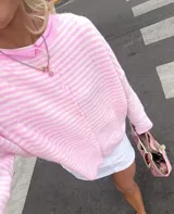 Buzo tejido a rayas horizontales rojas y blancas, con cuello tipo camisa y abotonadura frontal.