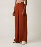 Pantalón pantalona verde manzana en crepé con pliegues, cierre por cremallera y sin estampado.