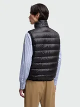 Chaleco puffer negro con diseño acolchado de costuras horizontales, cuello alto y cierre frontal de cremallera. Incluye el parche del logo de Moncler en el pecho.