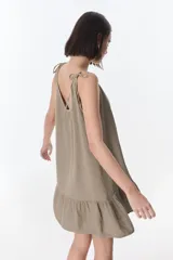 Vestido corto celeste con breteles finos y volados en el ruedo.
