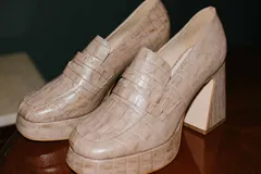 Mocasines color beige con estampado de piel de cocodrilo, plataforma y tacón cuadrado.