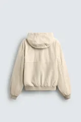 Cazadora relaxed fit color ladrillo confeccionada en tejido de algodón con estructura canvas. Tiene cuello con capucha ajustable, manga larga, bolsillos frontales de vivo, acabados con rib elástico, efecto lavado y cierre frontal de cremallera.