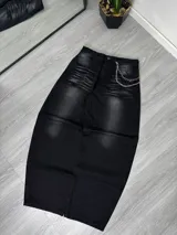 Pantalón de jean negro con lavado gastado, corte ancho y cadena metálica colgando del bolsillo.
