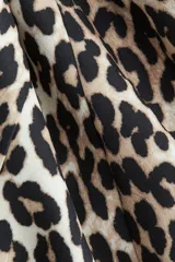Vestido corto sin mangas con estampado de leopardo. Modelo con escote bote, cierre oculto en un lateral y pollera con vuelo.