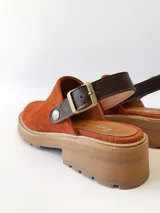 Zueco tipo sueco color ladrillo, hecho de cuero con detalle de hebilla.
