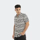 Camisa de manga corta con estampado geométrico en blanco y negro, cuello clásico y cierre frontal con botones.