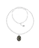 Collar largo plateado con cadena de eslabones y colgante ovalado con cristal facetado gris.