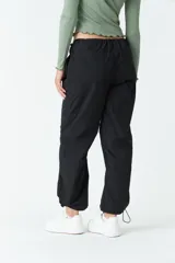 Pantalón negro de tiro medio, corte recto cropped y bolsillos laterales.