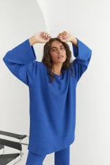Conjunto verde oliva de punto morley, compuesto por un buzo de corte holgado con mangas largas y aberturas laterales, y un pantalón palazzo de tiro alto.