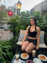 Top corto negro con escote drapeado y espalda descubierta.