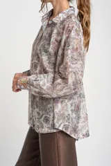 Camisa oversize de mangas largas con puños abotonados, cuello clásico y cierre frontal con botones. Estampado con motivos paisley en tonos pastel.