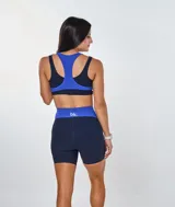 Conjunto deportivo de calza corta y top con logo 'bk.' estampado. El top es de color azul con base negra y la calza es de color azul marino con paneles laterales azules.