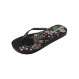 Ojotas negras con estampado floral en tonos rosa y verde.