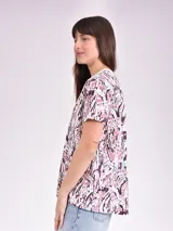 Remera estampada con motivos florales en tonos naranja, beige, gris y rosa.