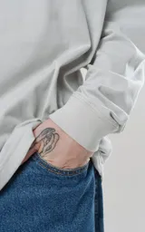 Remera manga larga gris con puños y cuello de ribb al tono, calce regular.