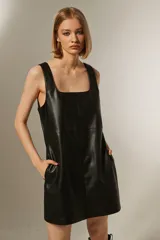 Vestido mini negro de eco-cuero, corte recto, sin mangas, con cuello cuadrado y cierre trasero.