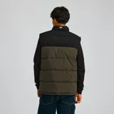 Chaleco acolchado Caterpillar, color marrón con parte superior negra, cierre frontal con cremallera, cuello alto y bolsillos laterales con cierre.