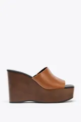Sandalias de cuña color marrón con plataforma de madera y tira ancha de cuero sintético color caramelo.