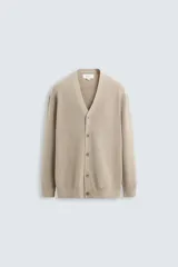 Cárdigan color beige de punto con mezcla de algodón y cashmere, de corte relaxed fit, cuello en pico, manga larga y cierre frontal con botones.
