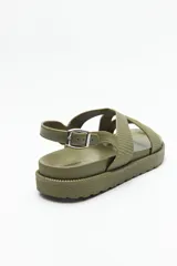 Sandalia color verde militar con tiras anchas cruzadas y hebilla metálica ajustable en el tobillo.