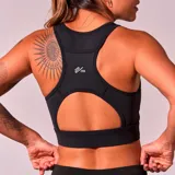 Top deportivo negro con breteles anchos y espalda deportiva.