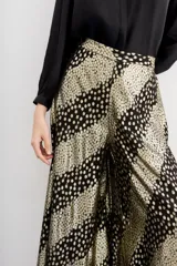 Pantalón amplio de viscosa jacquard con lurex, estampado con manchas de leopardo en negro y dorado. Tiene caída fluida, cintura con elástico trasero y forrería a tono.
