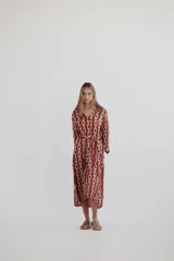 Vestido camisero color marrón con estampado de cadenas blancas, cuello camisero, mangas largas y lazo para ajustar en la cintura.