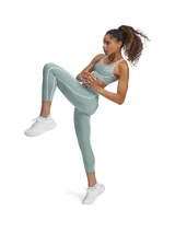 Top deportivo verde agua con breteles finos y contorno inferior blanco. Acolchado de espuma ultraliviana y tecnología de soporte que se sincroniza con los movimientos.