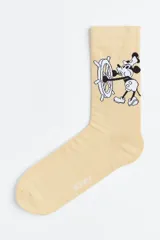 Medias color beige con diseño de Mickey Mouse timoneando un barco.