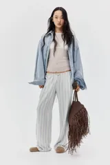 Pantalón de tiro bajo con elástico y cordón ajustable en la cintura, bolsillos al bies y piernas rectas. Confeccionado en tejido liviano con lino en la trama y estampado a rayas verticales en tonos celeste y beige.