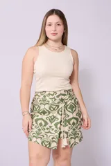 Short pollera con estampado tribal en tonos beige y verde, con cierre de lazo lateral y detalle de borlas.