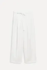 Pantalón blanco de tiro alto con trabillas, bolsillos laterales y falsos bolsillos de vivo en la espalda. Incluye cinturón lazada en el mismo tejido.