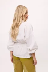 Chaqueta azul con cuello mao, mangas largas abullonadas y lazo en la cintura.