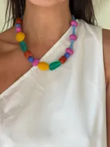 Collar corto con cuentas de cristal checo y acrílico de colores: rojo, azul, amarillo, verde y fucsia. Se cierra con cadena de acero quirúrgico y ganchito para regular el largo.