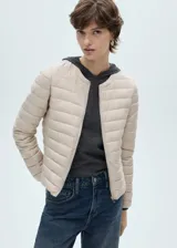 Campera acolchada color beige con cierre frontal y cuello redondo.