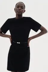 Vestido corto negro con cuello redondo, manga corta y cinturón fino extraíble con hebilla de metal.