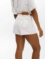 Short de jean blanco con costuras en color ocre, tiro alto y corte recto.