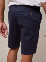 Bermuda color beige, de corte recto y largo hasta la rodilla.