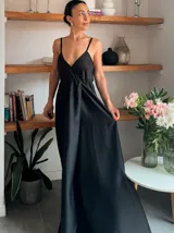 Vestido largo negro con breteles finos, escote en V cruzado y falda con abertura lateral.
