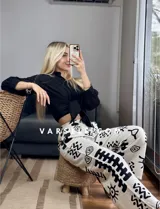 Pantalón palazzo blanco con estampado de motivos tribales en negro, cintura elástica y bolsillos laterales. Talle único.