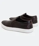 Championes slip on de cuero color marrón oscuro con suela blanca de goma.