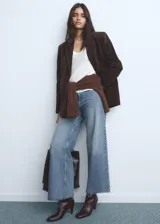 Jeans de mujer color azul claro, de tiro alto, corte wide leg y largo tobillero. Presenta bajo deshilachado, cierre de cremallera y botón, trabillas y bolsillos traseros.