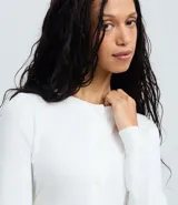 Cardigan blanco de punto liso con cuello redondo, mangas largas y cierre frontal con botones. El bajo es acanalado.