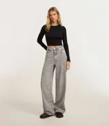 Pantalón wide leg de jeans gris lavado, tiro alto, con bolsillos delanteros y traseros, cierre con botón y cremallera.