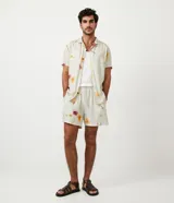 Bermuda boardshort color beige con estampado floral en tonos naranja y rosa.