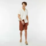 Camisa de manga corta color blanco hueso, de tejido calado con cuello solapa y bolsillo de parche en el pecho.