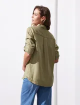 Camisa blanca de lyocell, marca Cyrus. Tiene cuello con solapa, abertura central con botones, mangas largas regulables con presilla y botón, y dos bolsillos delanteros aplicados.