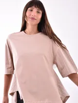 Remera de color beige con mangas a rayas y corte holgado.