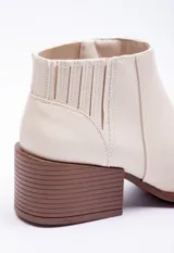 Botas marrones de símil cuero, tipo texanas, de caña baja y punta fina.