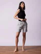 Short color beige de lino y rayón, con pretina elastizada, lazo de ajuste y bolsillos delanteros.